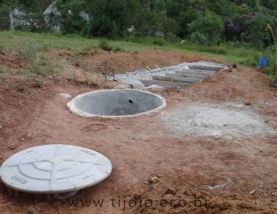 Biossistema em construção composto de biodigestor (coberto por tampa), filtro e zona de raízes.