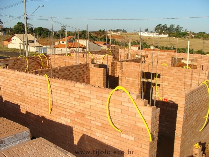 Obra em tijolos ecológicos onde se vê e estrutura e as instalações embutidas nos furos dos tijolos